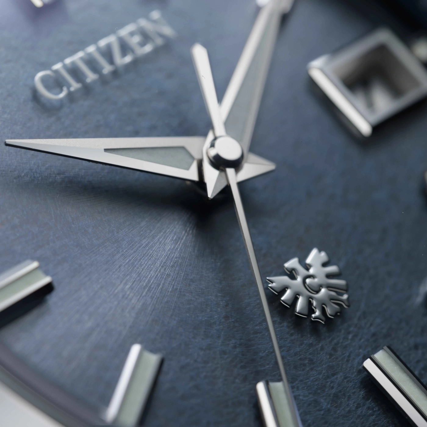 Gros plan d'une montre Citizen avec aiguilles et logo flocon de neige.