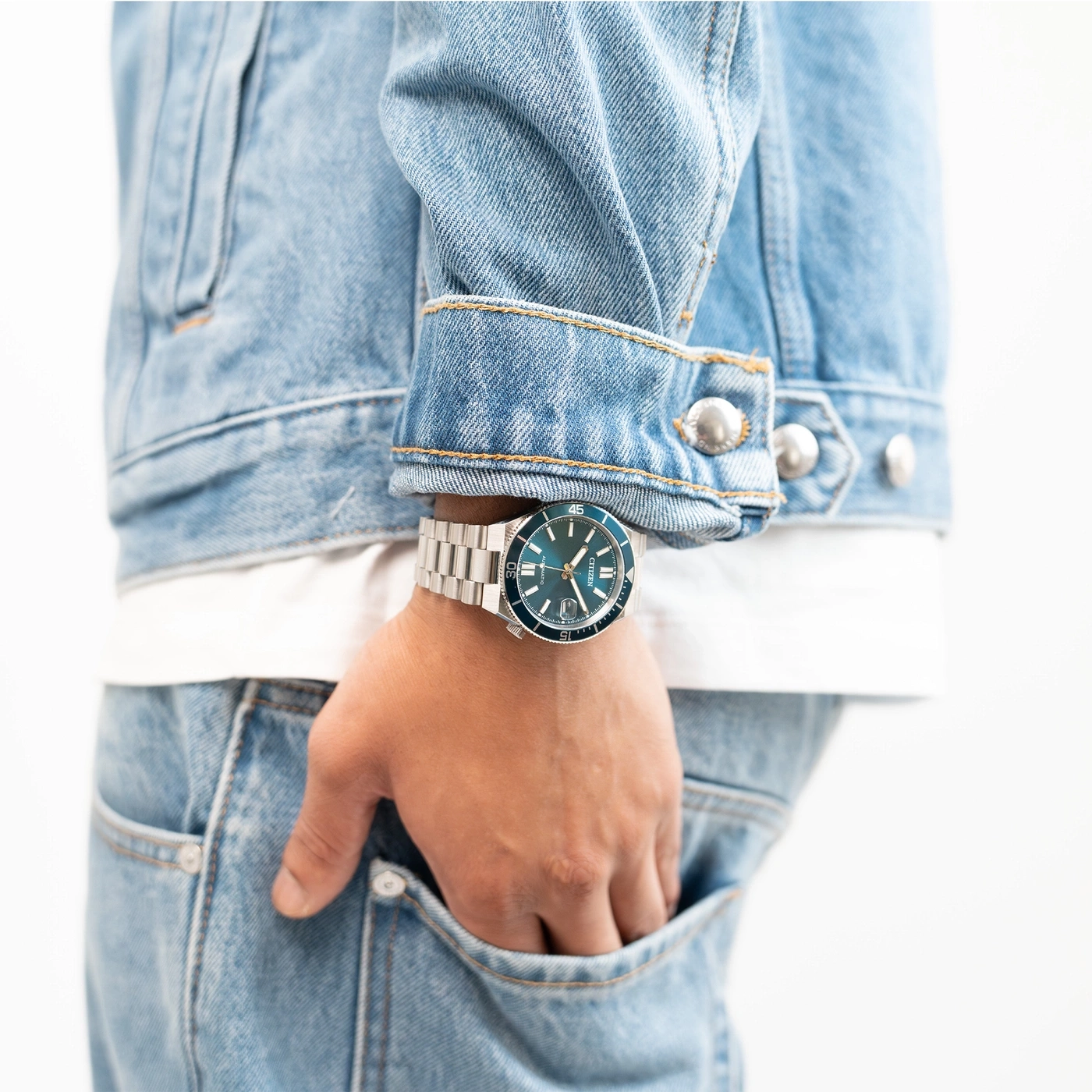 Homme portant une veste en jean et une montre Citizen bleue.