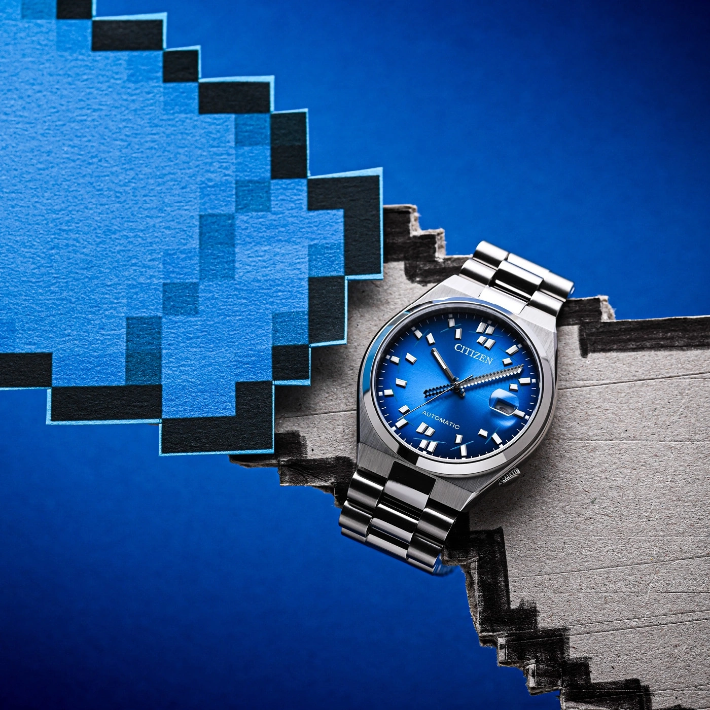 Une montre Citizen posée sur une image pixelisée bleue.