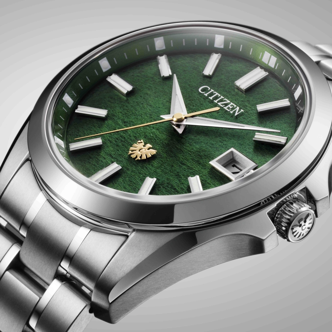 Montre Citizen verte avec bracelet en argent et logo doré.