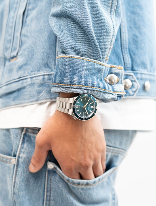 Homme portant une veste en jean et une montre bleue