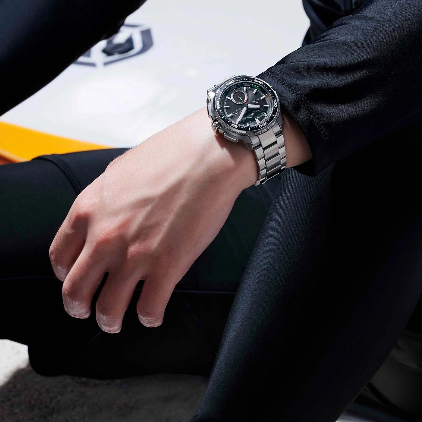 Homme portant une montre argentée sur un fond sombre