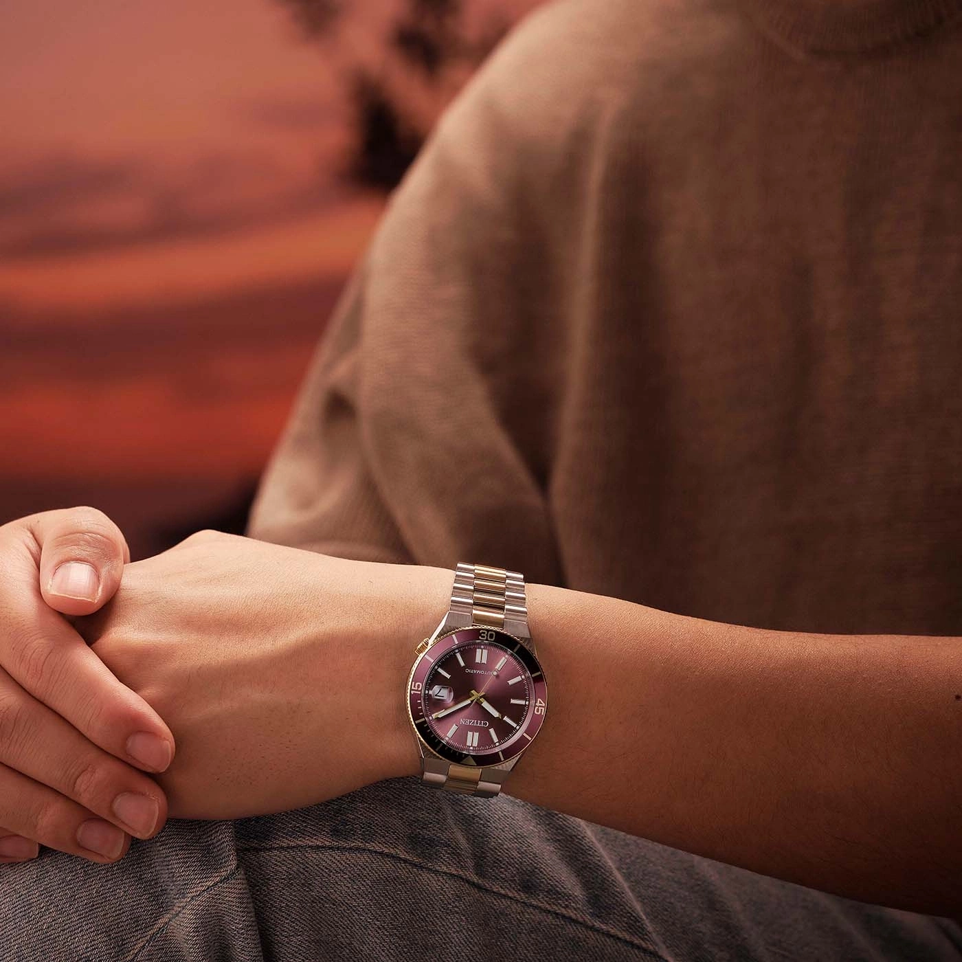 Homme portant une montre Citizen bicolore au coucher du soleil