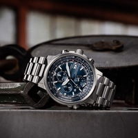 Montre Citizen avec cadran bleu et bracelet en métal sur surface métallique.