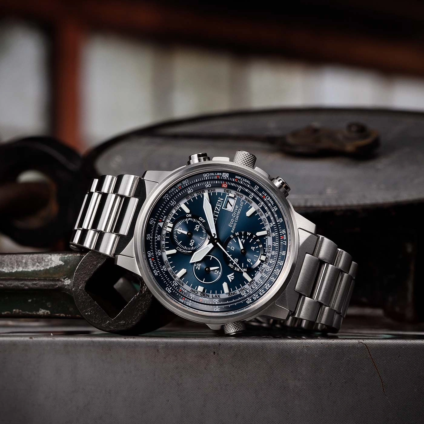 Une montre Citizen Eco-Drive posée sur une surface métallique avec des outils en arrière-plan.