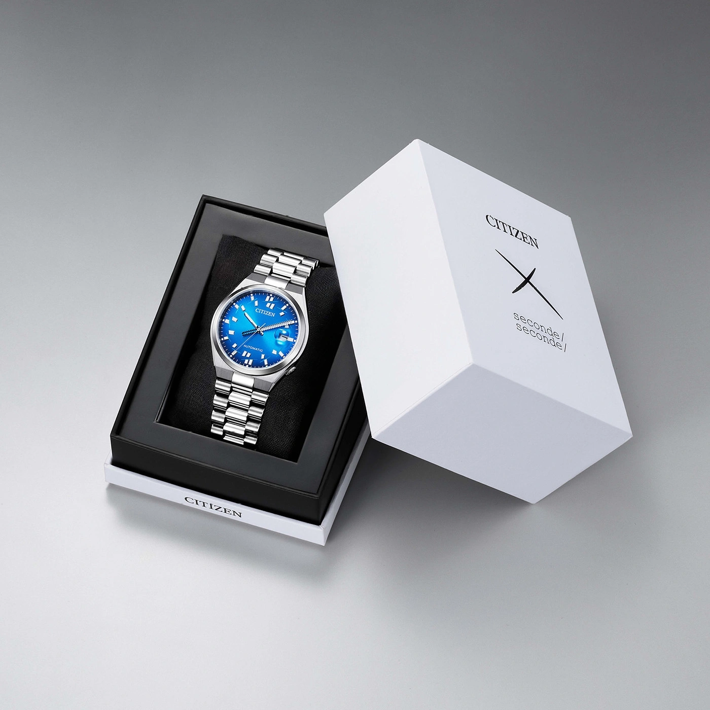 Montre Citizen automatique bleue dans une boîte blanche avec texte noir.