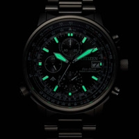 Gros plan d'une montre Citizen avec des accents verts lumineux et des détails complexes.