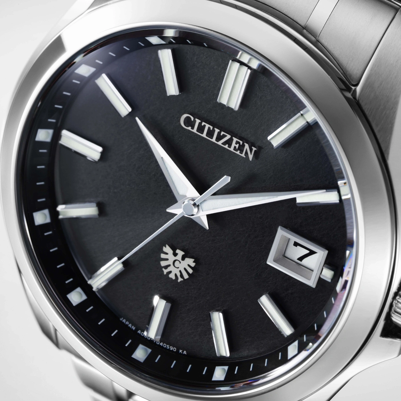 Gros plan sur une montre Citizen avec cadran noir et dateur.