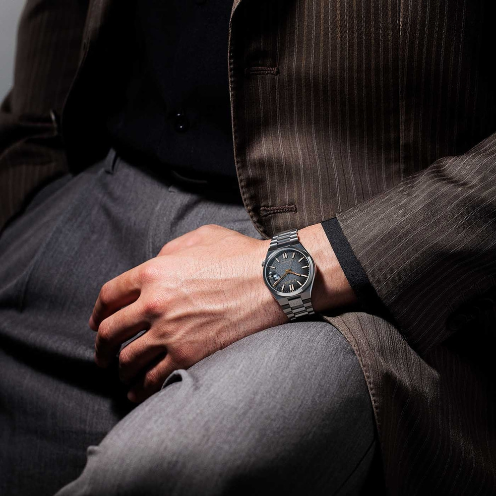 Homme portant une montre, un costume et un pantalon. Montre-bracelet au poignet.