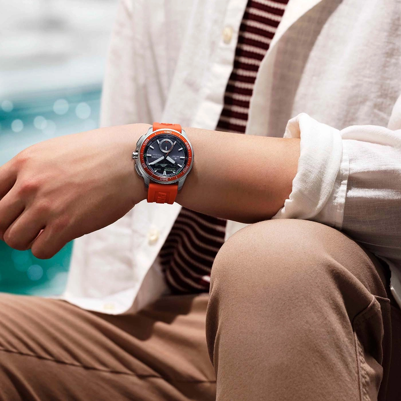 Mann trägt eine orangefarbene Citizen Eco-Drive Uhr am Handgelenk.