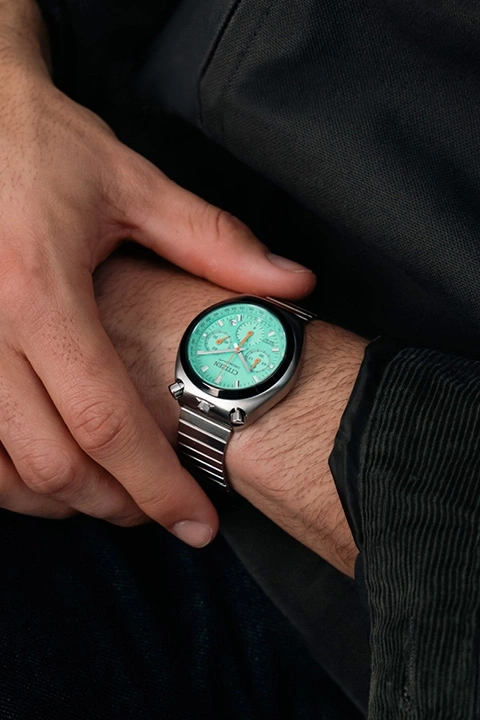 Homme portant une montre de sport argentée avec un cadran vert menthe.