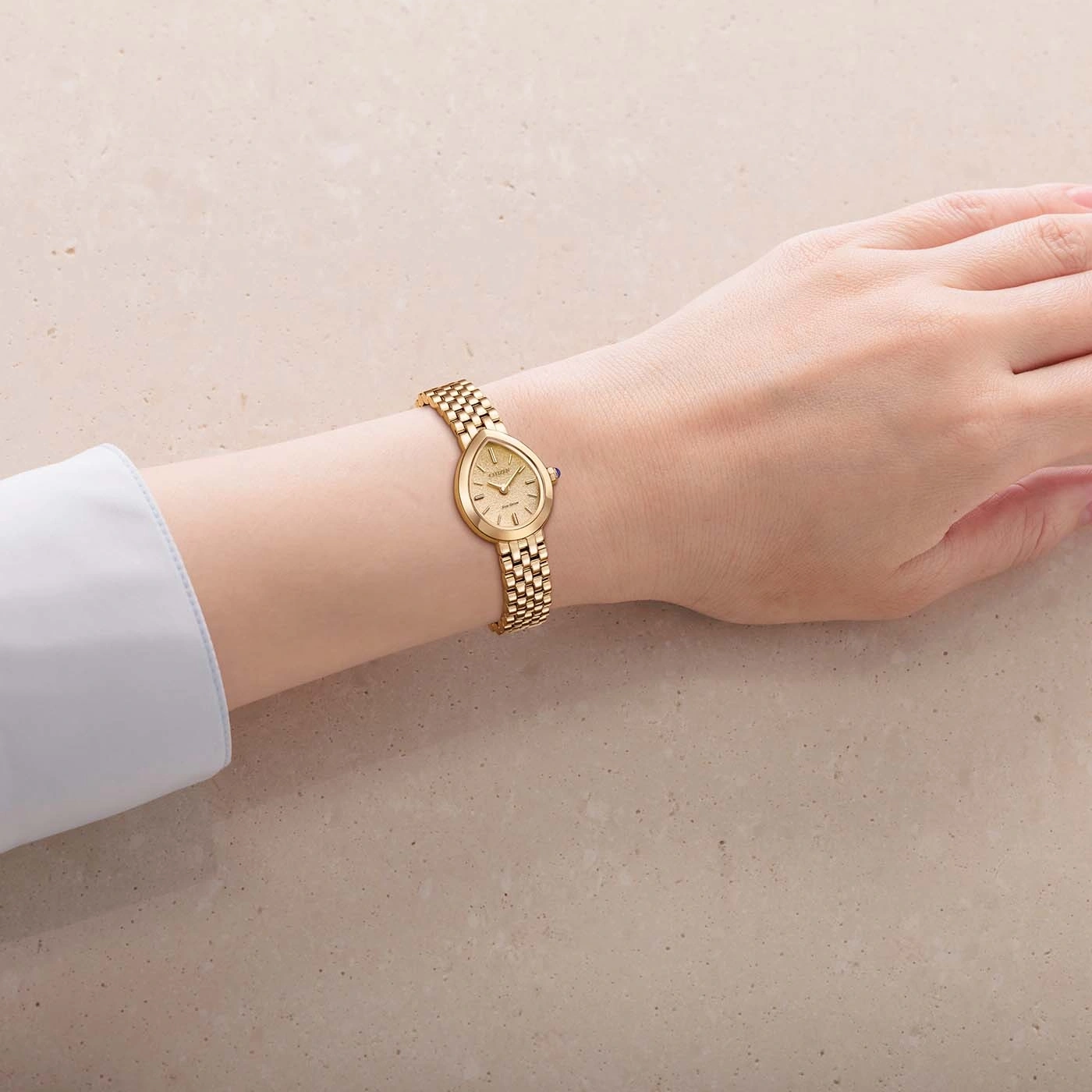 Une montre dorée élégante portée au poignet gauche d'une personne.