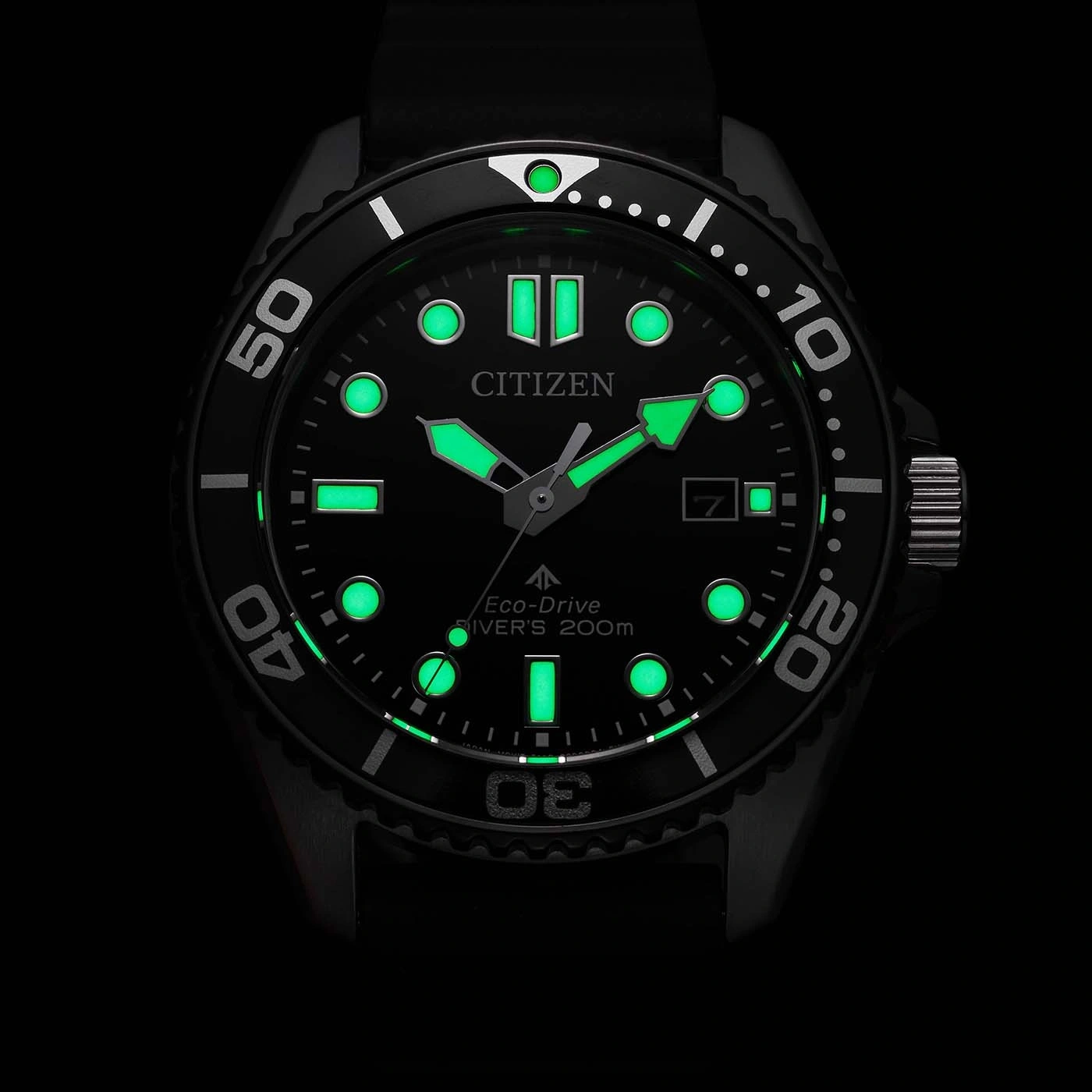 Une montre Citizen Eco-Drive pour plongeur est éclairée dans le noir.