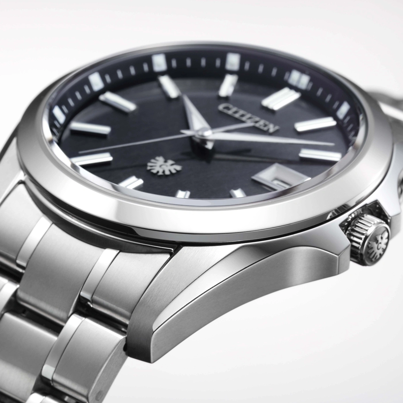 Gros plan d'une montre Citizen argentée avec un cadran noir et des index argentés.