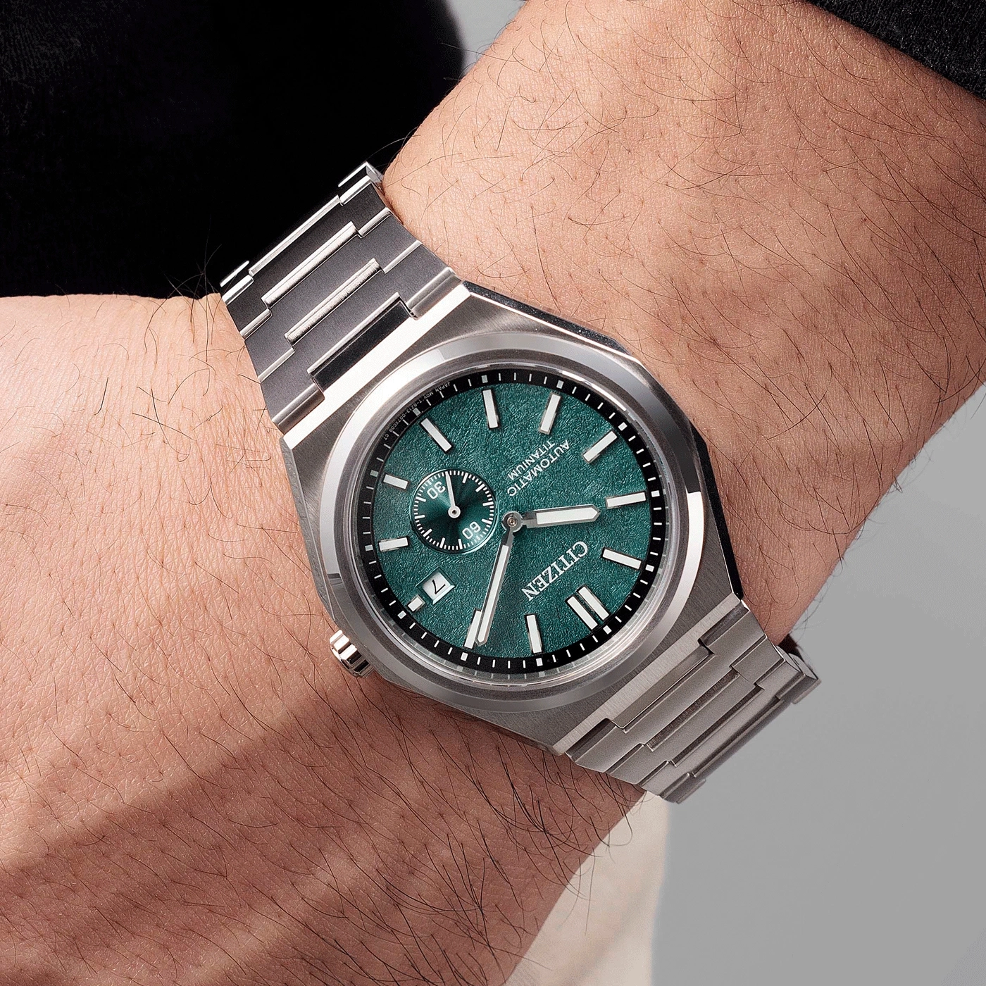 Une montre Citizen automatique en titane avec cadran vert sur un poignet