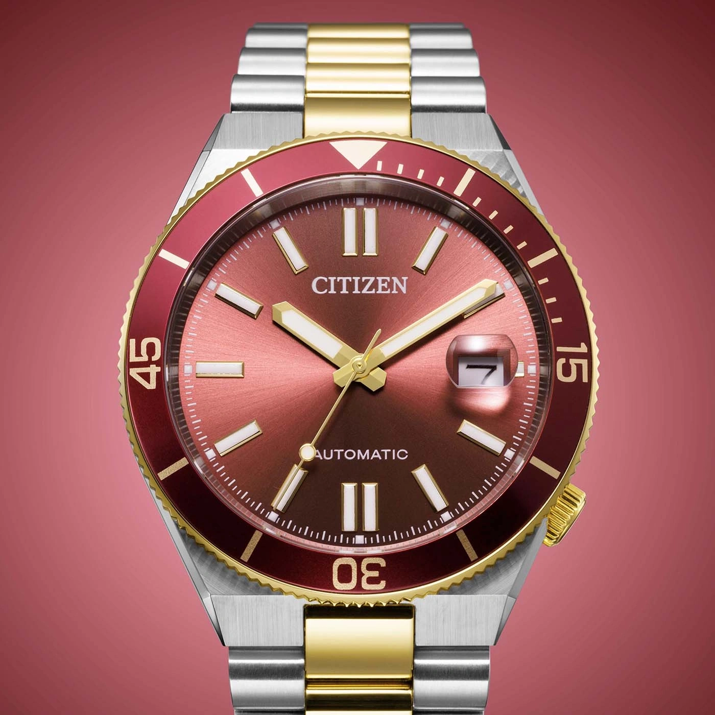 Une montre de plongée Citizen avec un cadran rouge et une lunette assortie, bracelet bicolore.