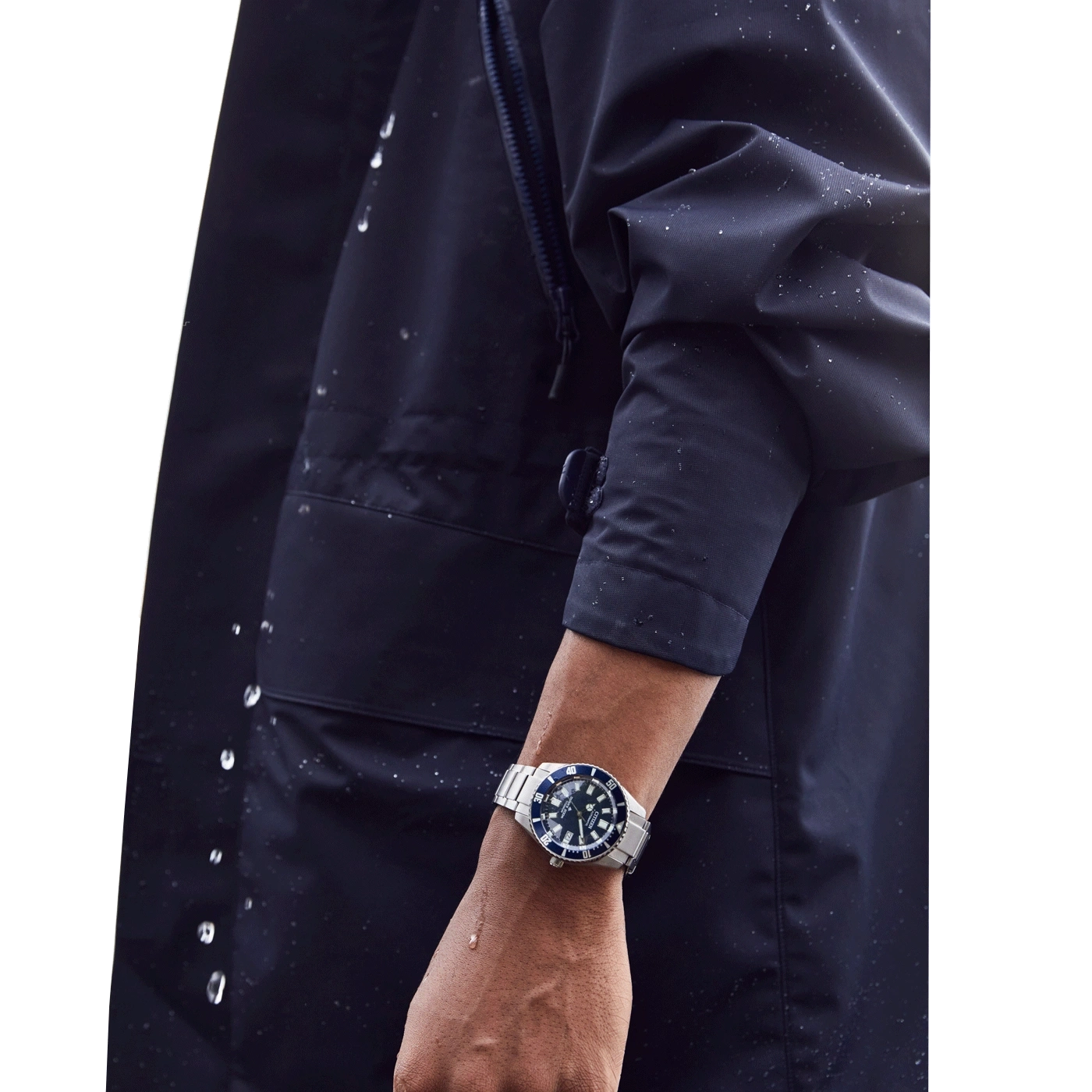 Une montre de plongée sur un bras portant une veste imperméable