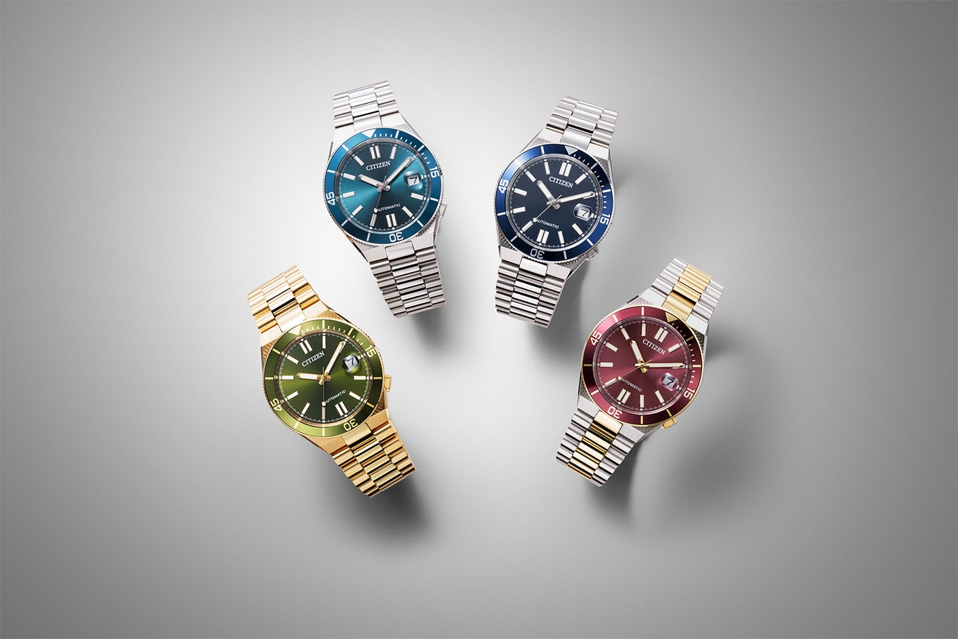 Quatre montres Citizen de différentes couleurs sur fond gris.