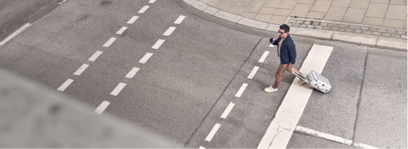 Homme avec valise traversant la rue sur un passage piéton