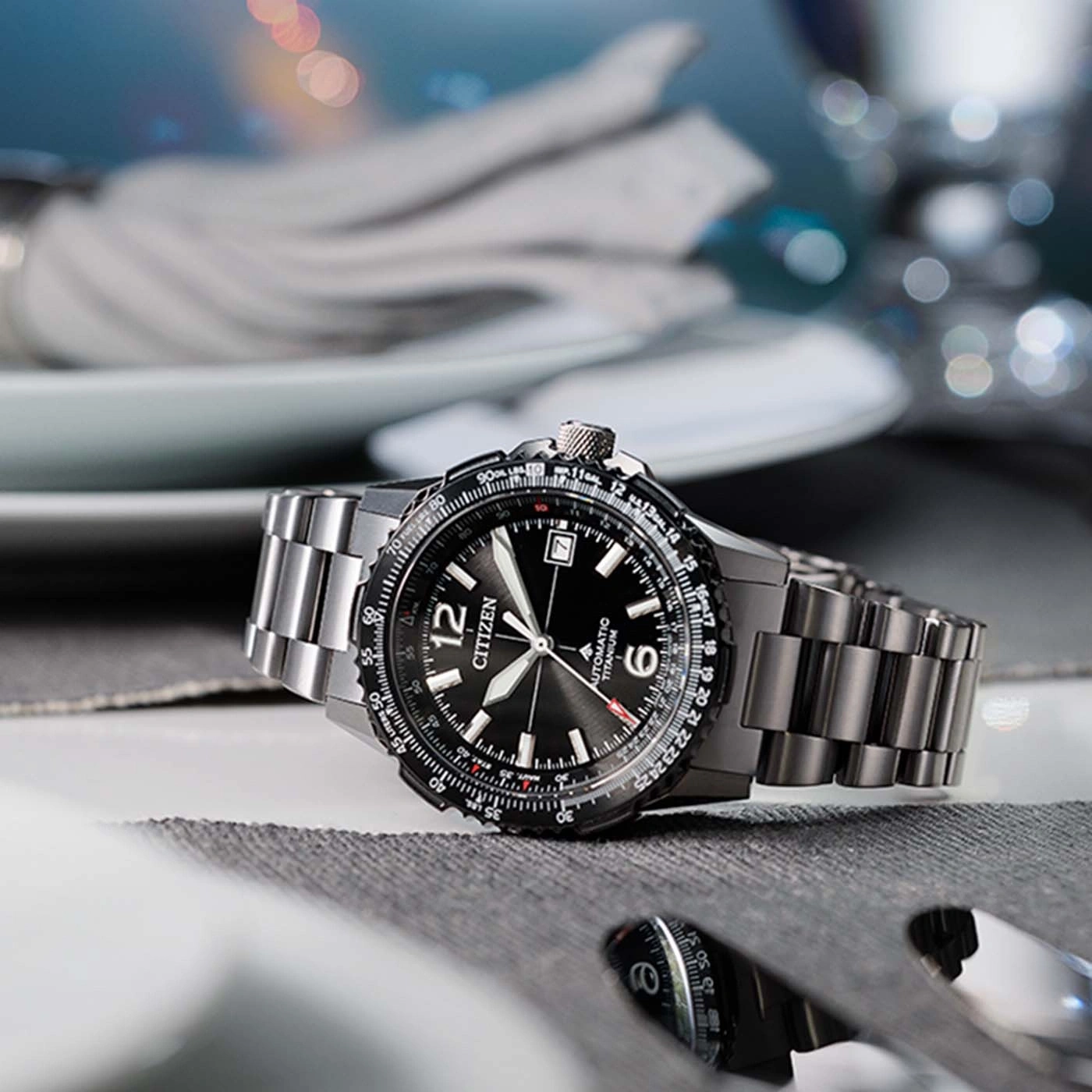 Une montre Citizen automatique en titane sur une table dressée.
