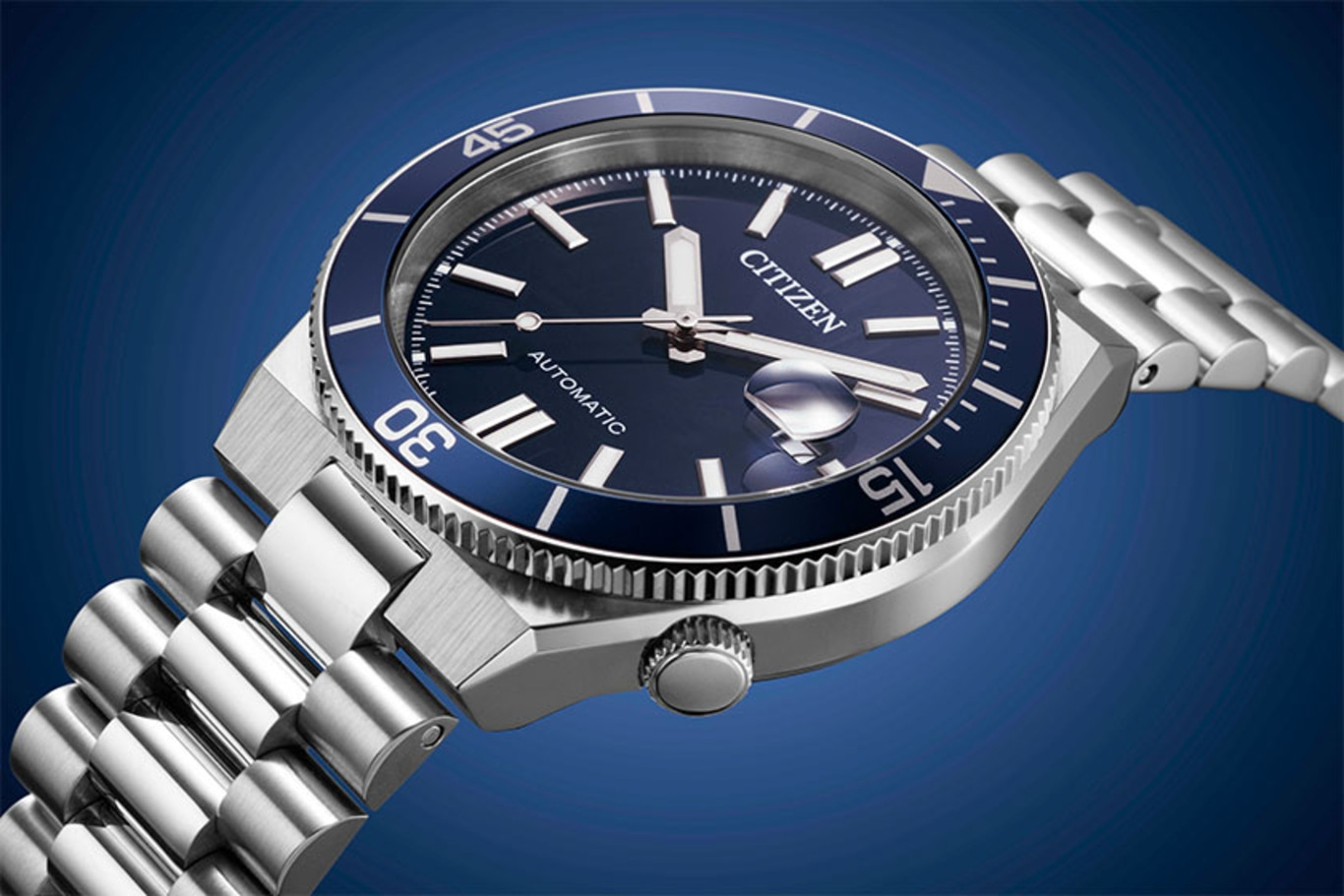 Montre Citizen automatique bleue avec bracelet en argent sur fond bleu.