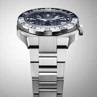 Gros plan d'une montre argentée avec une lunette bleue et blanche et un bracelet en métal.