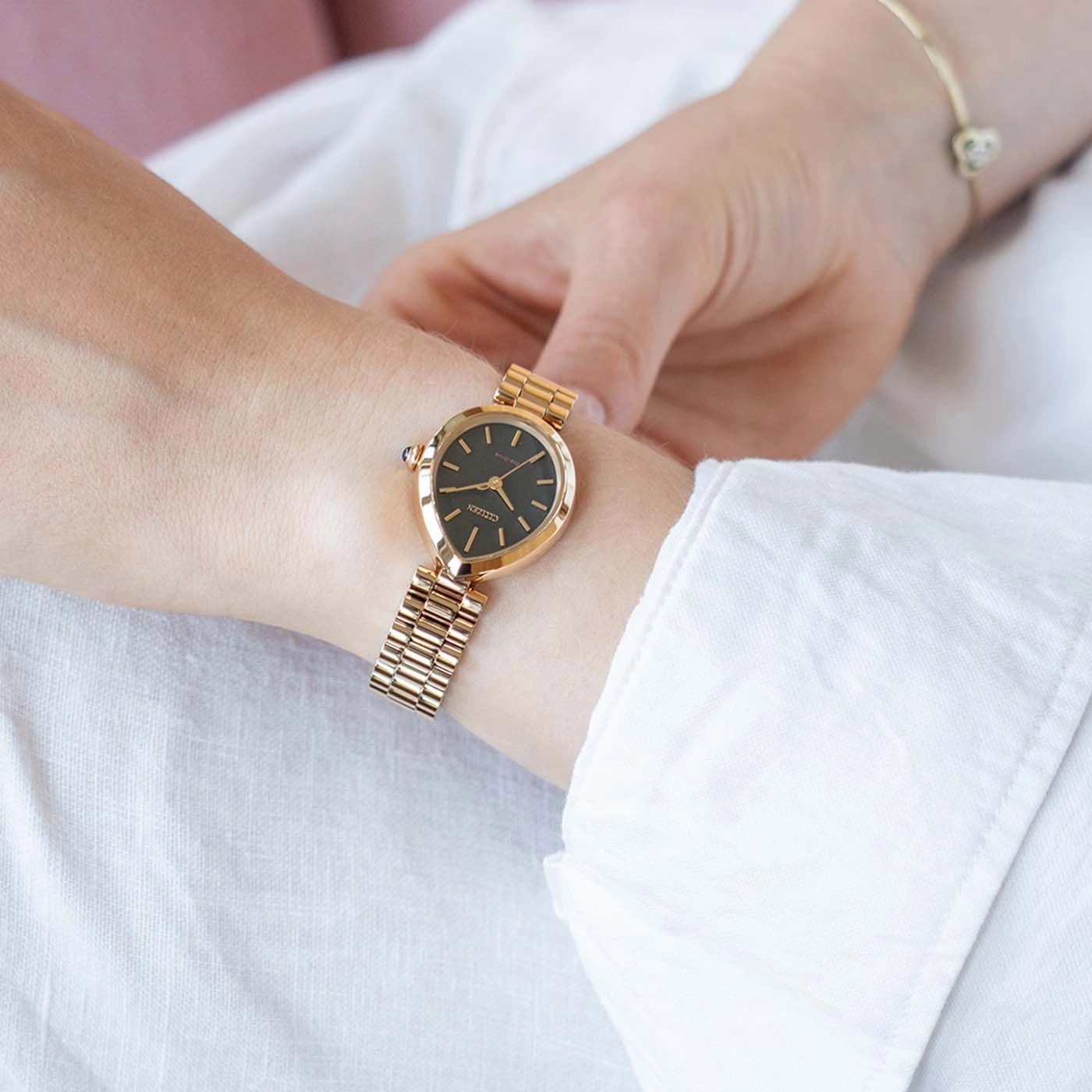Frau trägt eine goldene Citizen-Uhr mit Armband und Herz.