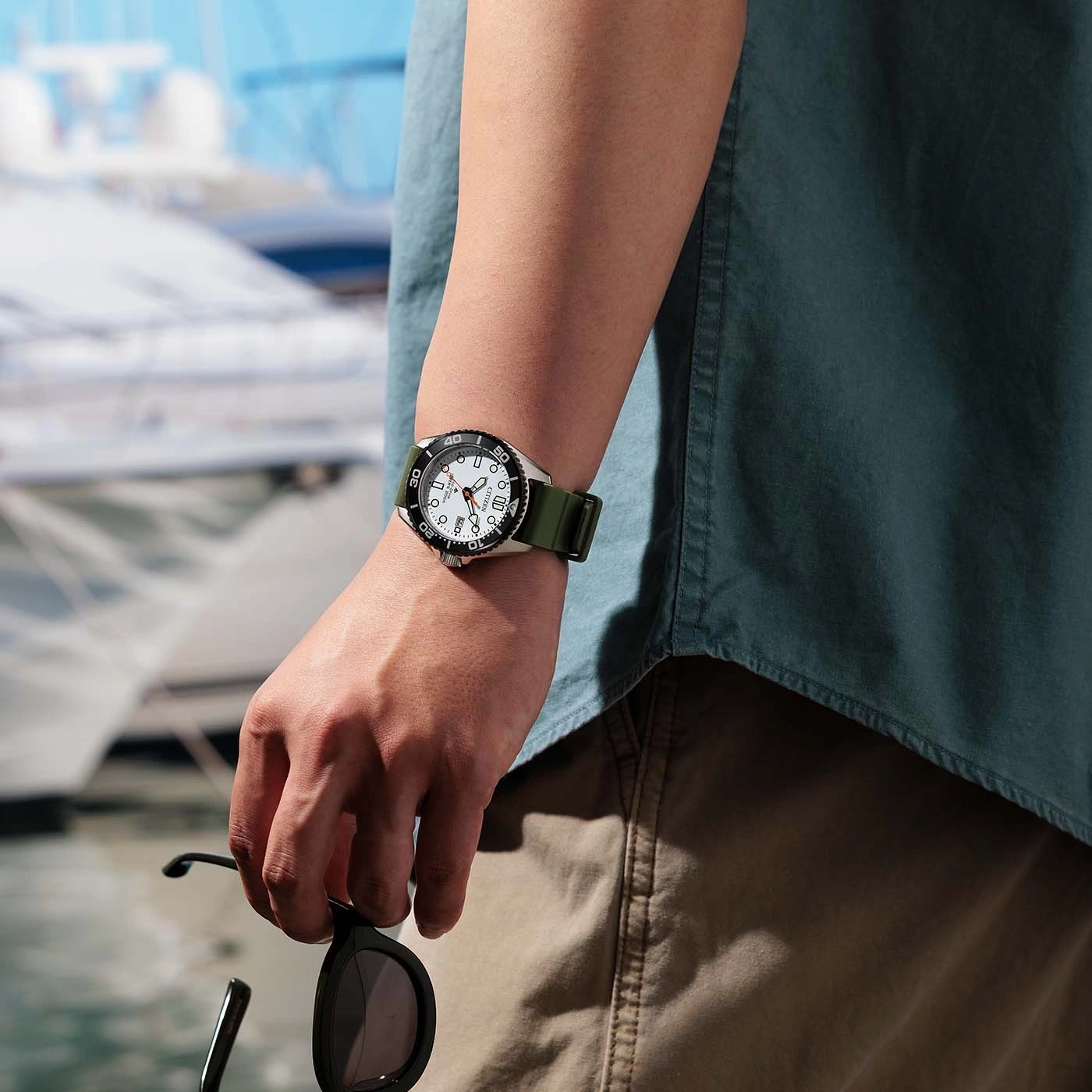 Un homme portant une montre et des lunettes de soleil sur un bateau.