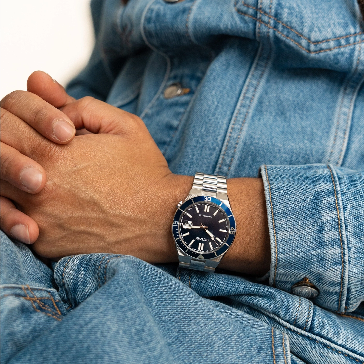Montre de plongée Citizen sur un bras vêtu de jean
