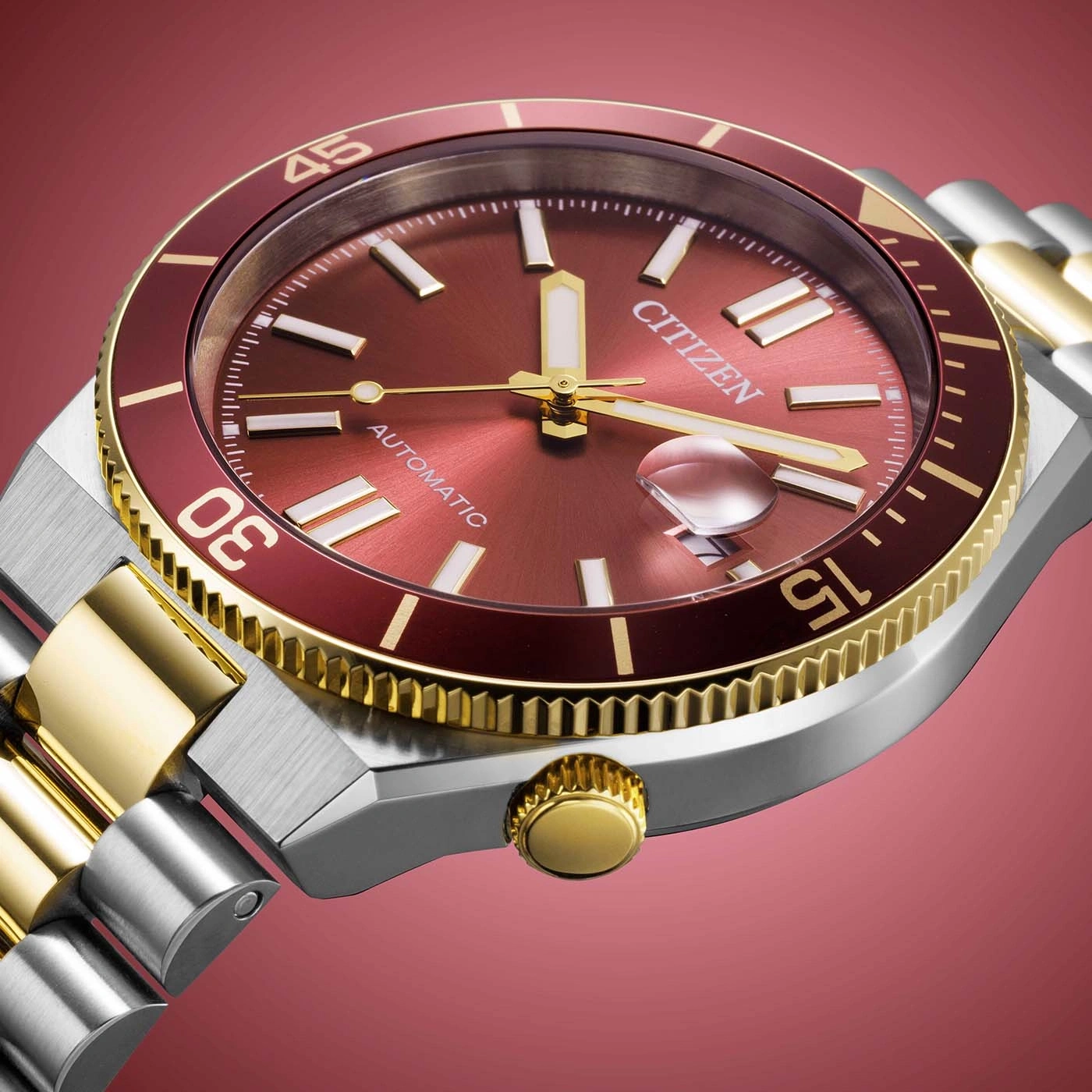 Montre Citizen rouge et or, gros plan sur le cadran et le bracelet.