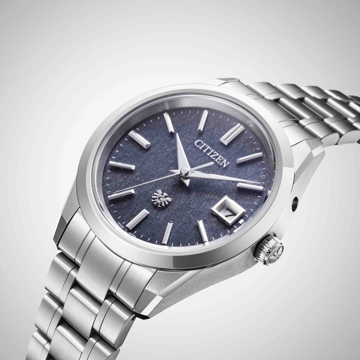 Une montre Citizen argentée avec un cadran bleu et un bracelet en métal.