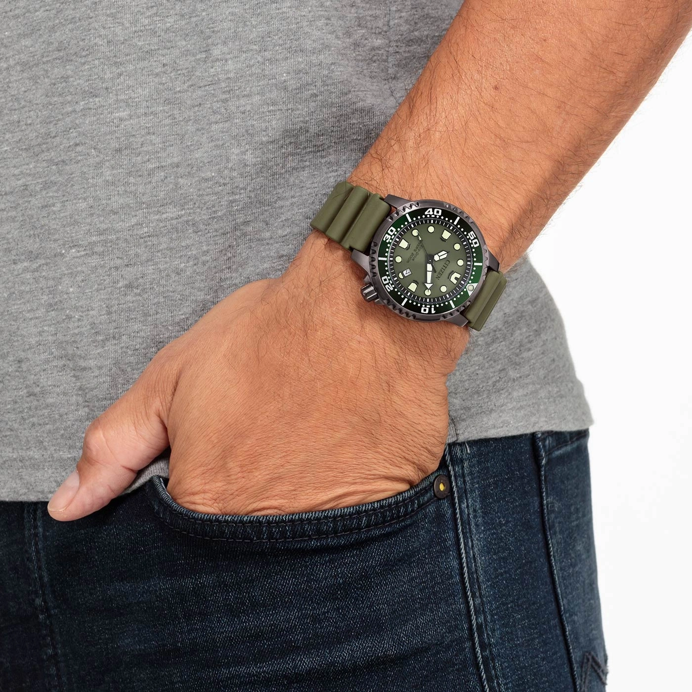 Un homme porte une montre verte avec un bracelet en caoutchouc.